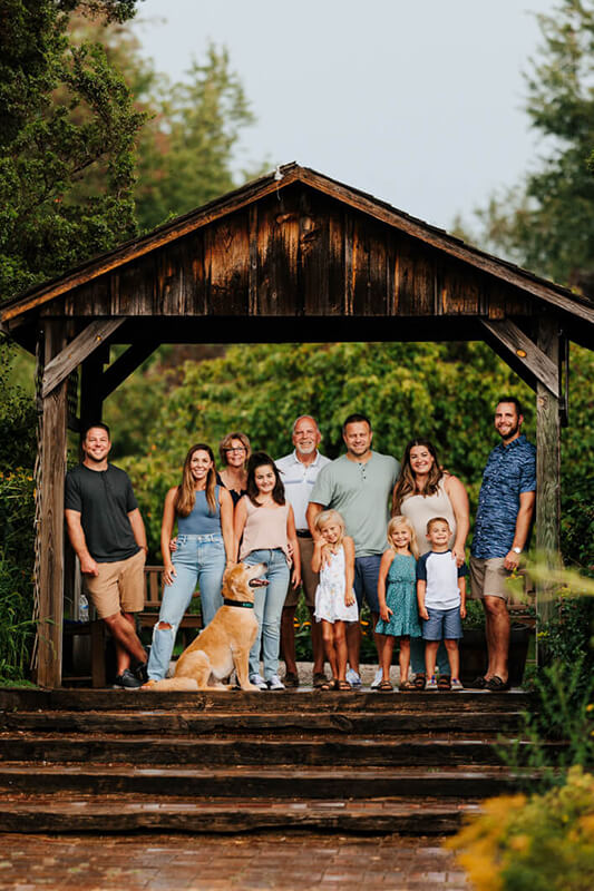 Extended family group portrait under wooden pavilion during family photography session best West Michigan family photographer