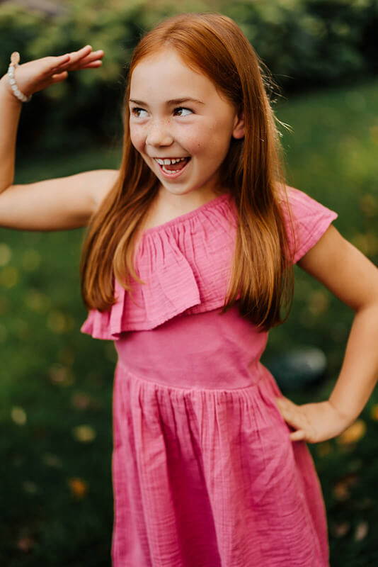 Young girl in pink dress laughing candidly during Grand Rapids family photography session GAUPERfamilies Michigan