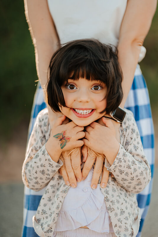 Candid portrait of young girl smiling up at camera during family photography session Grand Rapids Michigan